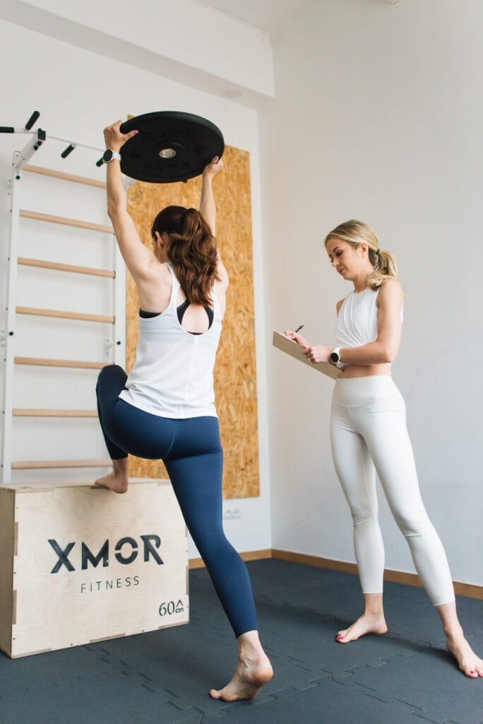 Klientka podnosi ciężary na treningu personalnym dla kobiet w Poznaniu rozciągając mięśnie nóg