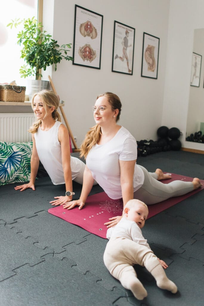 Trenerka Ula z kobietą z dzieckiem rozciąganie podczas treningu po porodzie Poznań
